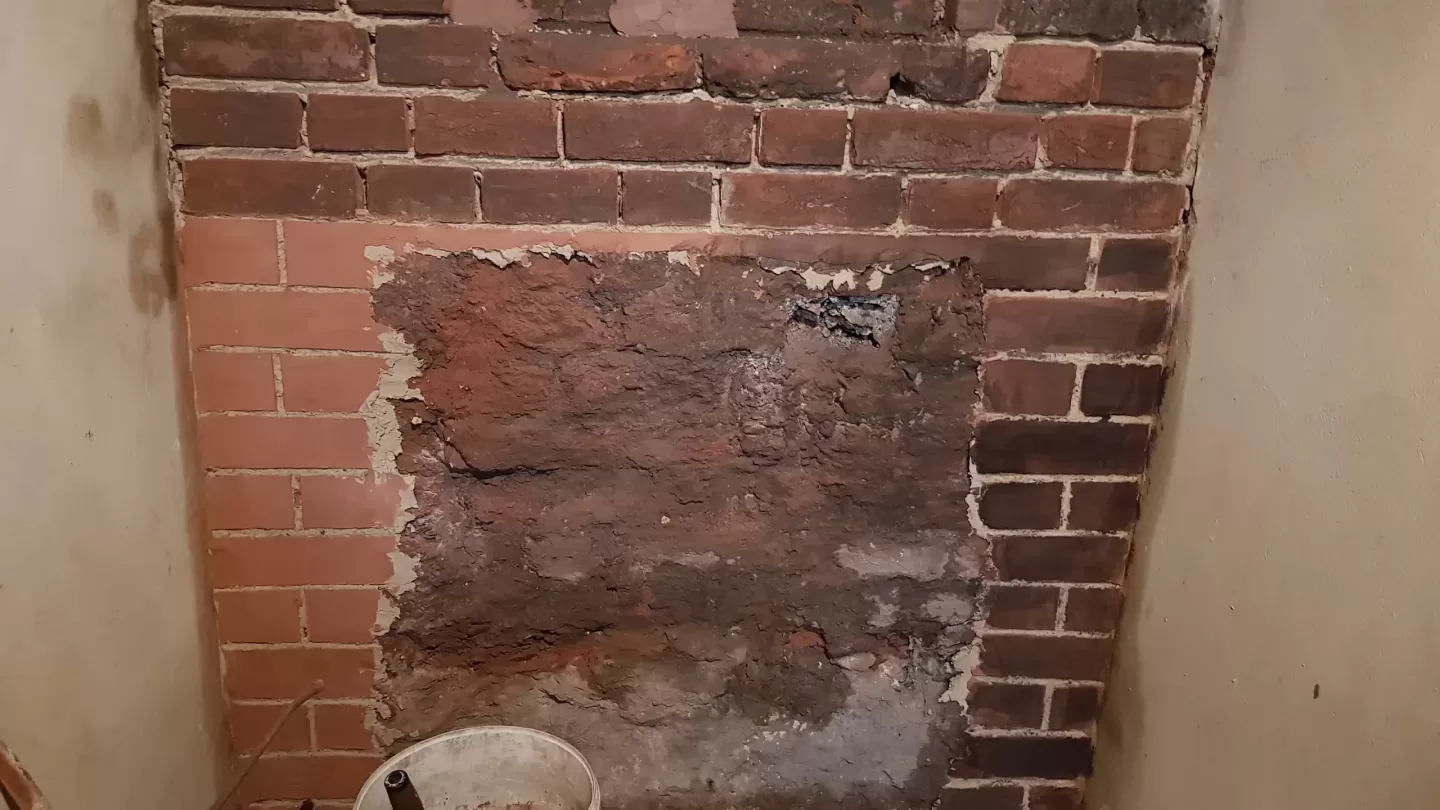 Repairs to wall behind Aga with coloured lime mortar in Georgian house.